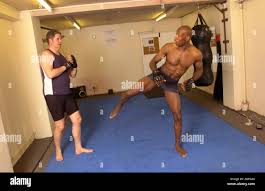 Mark Weir known as "The Wizard" a British middleweight Mixed Martial Arts fighter pictured training a white opponent in his gym Stock Photo - Alamy